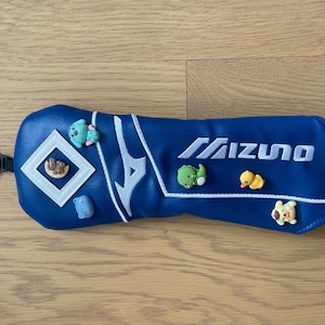 Könnte beinhalten: Ein Set aus drei Keramikbechern mit gesprenkelter, cremefarbener Glasur. Jeder Becher zeigt ein handgemaltes Blumenmuster in Blau-, Grün- und Gelbtönen. Die Becher haben eine einfache, abgerundete Form und einen bequemen Griff.