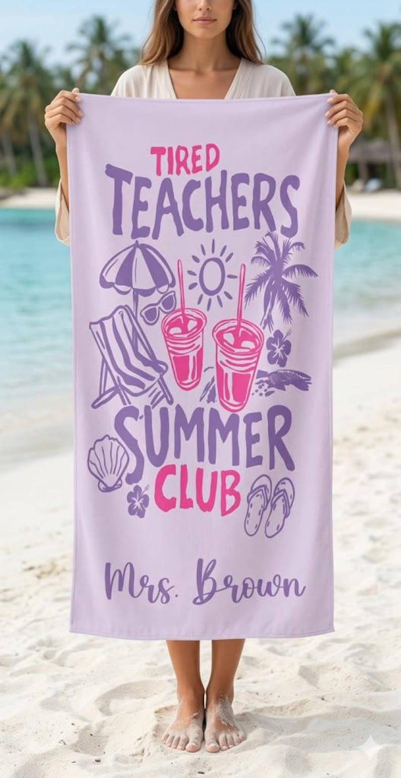 May include: A lilac beach towel with the text "Tired Teachers Summer Club" in purple and pink. The towel has illustrations of beach items, including a parasol, sunglasses, drinks, a deckchair, and Mrs. Brown's name.