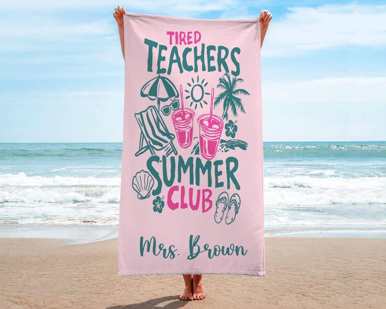 May include: A pink beach towel with the words "Tired Teachers Summer Club" in teal and pink. The towel features illustrations of a beach umbrella, sunglasses, drinks, a beach chair, a seashell, flowers, and flip-flops. The name "Mrs. Brown" is printed at the bottom.
