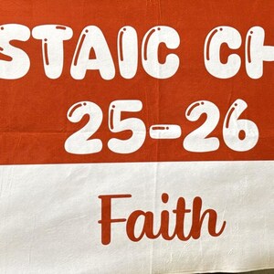 May include: A red and white banner with the words "CASTAIC CHEER 25-26" in white bubble letters. The word "Faith" is in red script. Pom-poms are on each side.