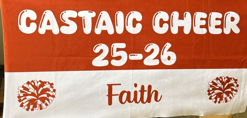 May include: A red and white banner with the words "CASTAIC CHEER 25-26" in white bubble letters. The word "Faith" is in red script. Pom-poms are on each side.