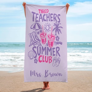 May include: A lilac beach towel with the words "Tired Teachers Summer Club" in purple and pink. The towel has illustrations of a parasol, sunglasses, drinks, a deckchair, and a palm tree. The name "Mrs. Brown" is printed at the bottom.
