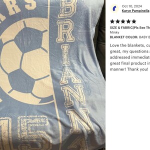 May include: Baby blue blanket with white text and a soccer ball graphic. The blanket features the name "BRIAN" vertically and "VARSITY HILL 15" in a circular design. The blanket measures 50x60 inches.