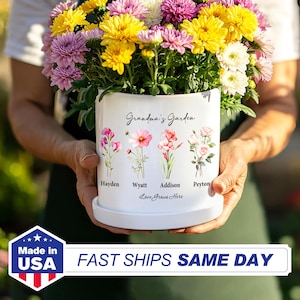 May include: White ceramic flower pot with a floral design and the text "Grandma's Garden". The pot has four names printed below the flowers: Hayden, Wyatt, Addison, and Peyton. The text "Love Grows Here" is printed below the names.