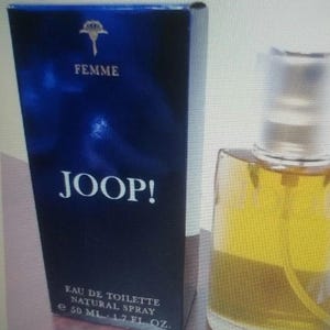 Könnte beinhalten: Ein Parfümflaschen- und Box-Set. Die Box ist dunkelblau mit dem Wort "FEMME" und "JOOP!" in Weiß. Die Flasche enthält eine gelbe Flüssigkeit und ist mit "EAU DE TOILETTE NATURAL SPRAY" beschriftet und hat 50 ml.