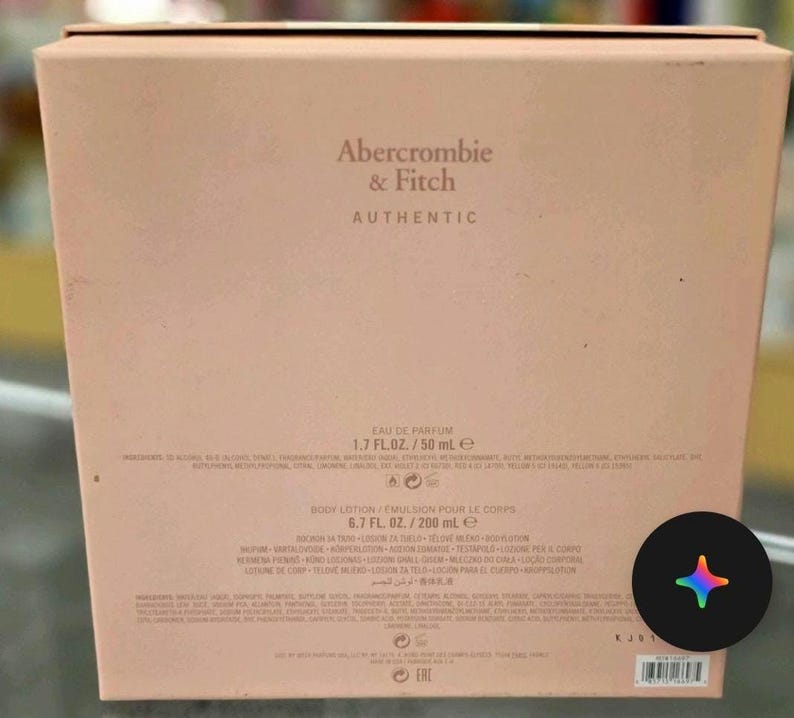 Może przedstawiać: Jasnor&oacute;żowe pudełko zapachowe Abercrombie & Fitch Authentic. Pudełko zawiera tekst "EAU DE PARFUM 1,7 FL. OZ./50 ml e" i "BODY LOTION/EMULSION POUR LE CORPS 6,7 FL. OZ./200 ml e".