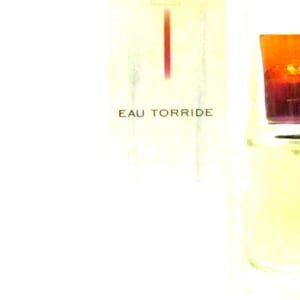 May include: A clear glass bottle of perfume with a red and orange cap. The bottle is labelled "EAU TORRIDE".