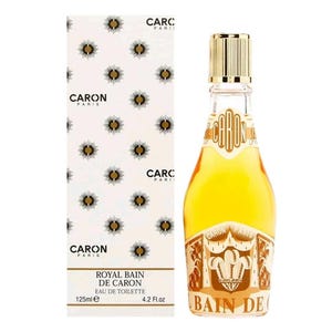 May include: A 125ml bottle of Royal Bain de Caron Eau de Toilette with a gold cap and amber liquid, alongside its white rectangular box featuring a repeating dark floral pattern, the Caron Paris logo, and the text Royal Bain de Caron 4.2 Fl.oz.