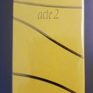 Puede incluir: Caja de perfume rectangular amarilla con el texto "ESCADA acte 2". La caja también tiene las palabras "Eau de Parfum", y el volumen se indica como 1,7 FL.OZ. y 50 ml.
