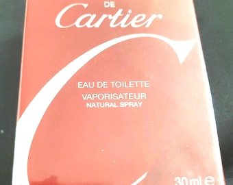 Può includere: Una scatola rossa di "Must de Cartier" Eau de Toilette. La scatola presenta testo bianco e un grande design "C" bianco. L'angolo in basso a destra indica un volume di 30 ml o 1 fl. oz.