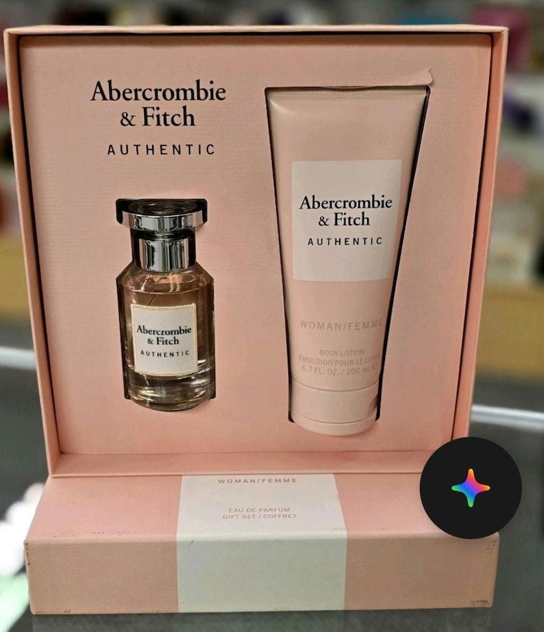 Może przedstawiać: R&oacute;żowy zestaw prezentowy Abercrombie & Fitch AUTHENTIC dla kobiet, zawierający perfumy i balsam do ciała. Zestaw zawiera butelkę perfum i tubę balsamu. Na pudełku widnieje logo marki i napis "WOMAN/FEMME".