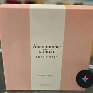 Może przedstawiać: Prostokątne r&oacute;żowe pudełko prezentowe z białym pionowym paskiem. Zawiera tekst "Abercrombie & Fitch AUTHENTIC" i "WOMAN/FEMME". Na dole pudełka widnieje napis "EAU DE PARFUM GIFT SET/COFFRET".