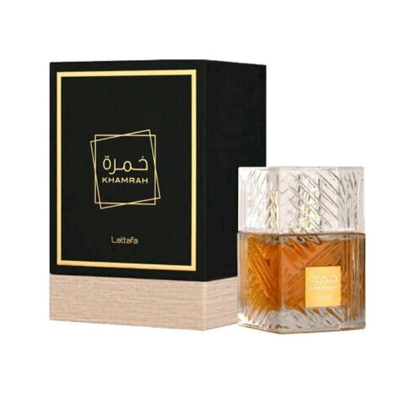 May include: A rectangular black perfume box with gold trim and the text Khamrah and Lattafa, paired with a square glass perfume bottle featuring a textured geometric pattern and amber liquid, displaying a gold label with Arabic script.