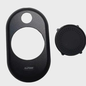 May include: Black plastic car accessory set. The set includes an oval-shaped piece with a large central opening and a smaller circular opening at the top, along with a separate round piece. The text "CLP1040" is printed on the oval piece.