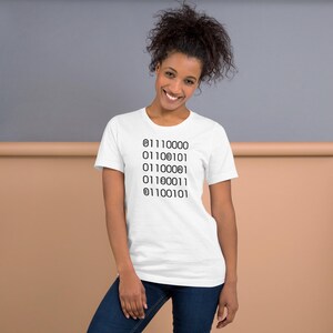 May include: White short-sleeved t-shirt with black binary code printed vertically on the front. The binary code consists of six lines of numbers. The model is wearing blue jeans.