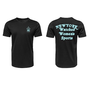 May include: Black t-shirt with a light blue crown and "NY" logo on the front. The back of the shirt features the words "NEW YORK Watches Women's Sports" in light blue. A casual tee for sports fans.