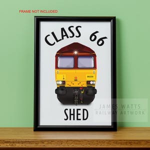 Peut inclure: Une impression blanche avec du texte noir qui dit "Class 66 Shed" avec une locomotive diesel jaune et rouge au centre. La locomotive porte le numéro 66238 sur le côté.
