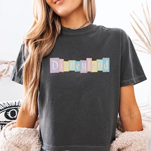 A woman wearing a black t-shirt with the word "Disneyland" printed on it.