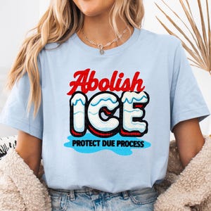 a woman wearing a blue shirt that says abollish ice