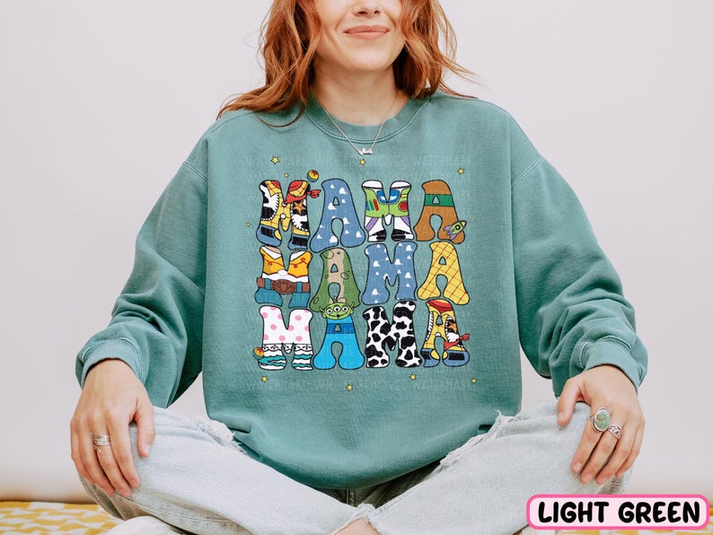 a woman sitting on a bed wearing a green sweatshirt