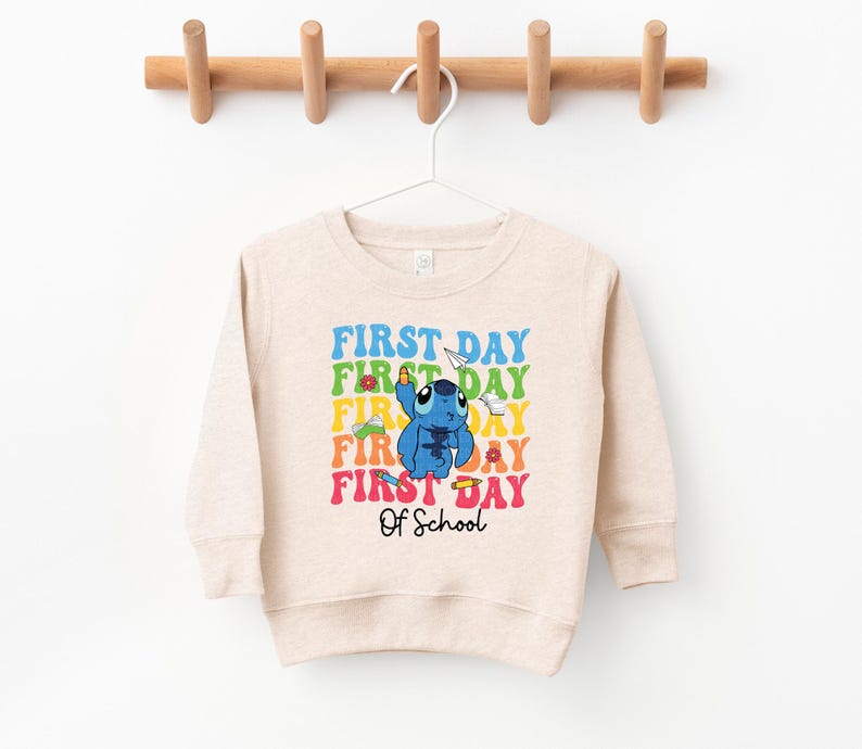 a sweater hanging on a clothes rack with a wooden hanger