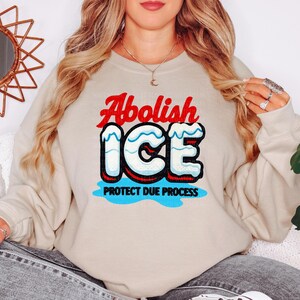 a woman wearing a sweatshirt that says abollish ice and protect due process