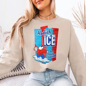 a woman sitting on a bed wearing a sweatshirt