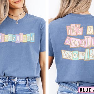 A woman wearing a blue t-shirt with the text "Disneyland it's a small world" printed on it.