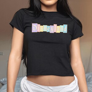 A woman wearing a black t-shirt with the word "Disneyland" printed on it.