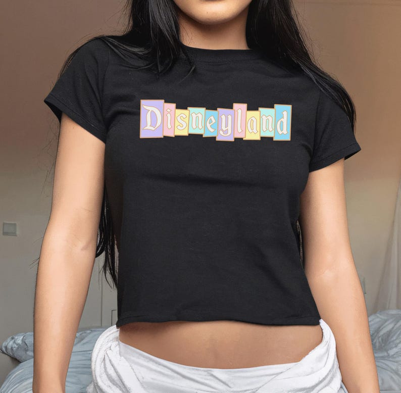 A woman wearing a black t-shirt with the word "Disneyland" printed on it.
