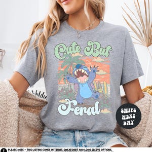 a woman sitting on a couch wearing a shirt with a cartoon character on it