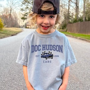 a young boy standing on the side of a road