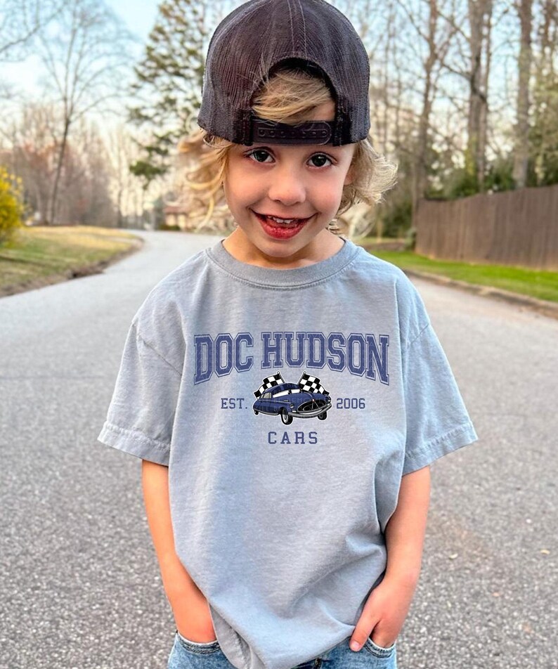 a young boy standing on the side of a road