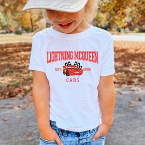 a little girl wearing a white hat and a white t - shirt