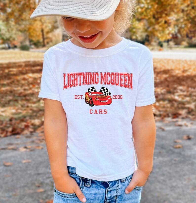 a little girl wearing a white hat and a white t - shirt