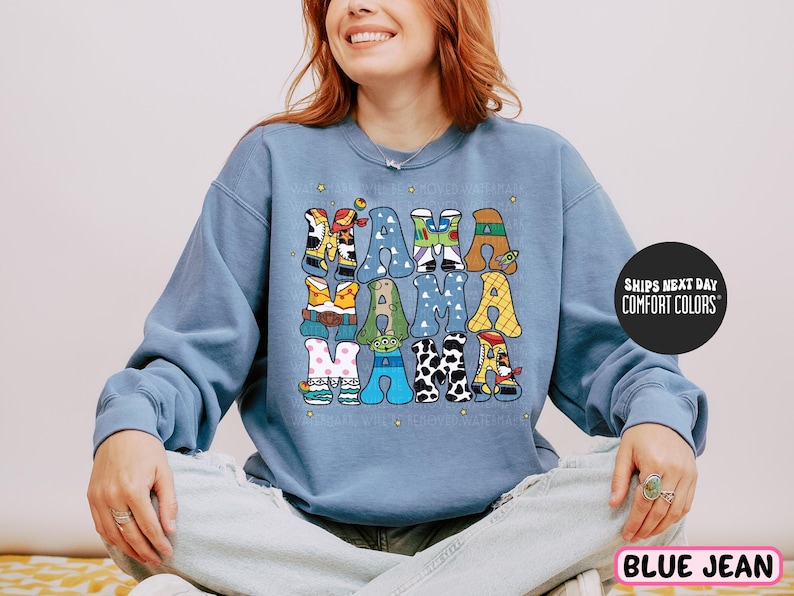 a woman sitting on a bed wearing a blue sweatshirt