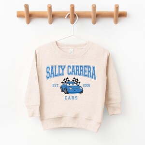 a white sweatshirt hanging on a wooden hanger