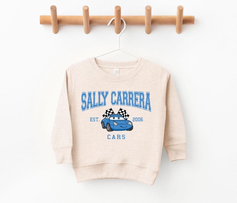 a white sweatshirt hanging on a wooden hanger