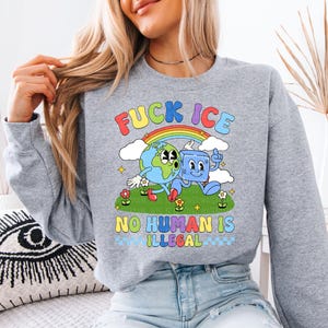 a woman sitting on a couch wearing a sweatshirt