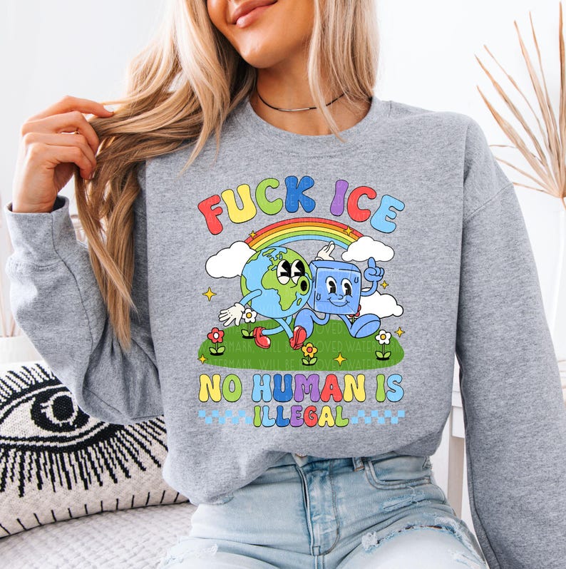 a woman sitting on a couch wearing a sweatshirt