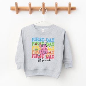 a gray sweatshirt hanging on a wooden hanger