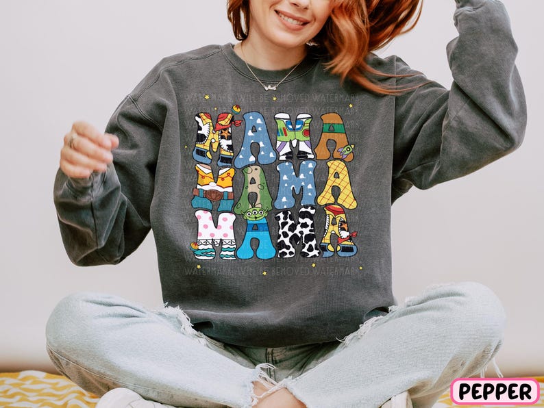 a woman sitting on a bed wearing a sweatshirt with letters on it