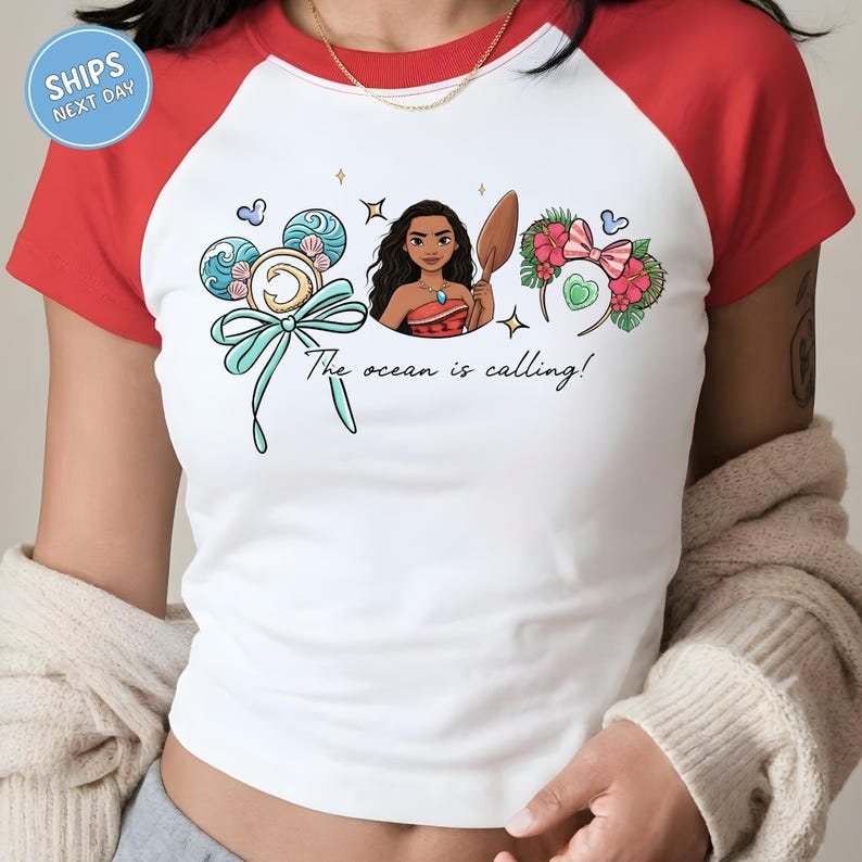 A person wearing a white and red t-shirt with a graphic design featuring a cartoon character and text.