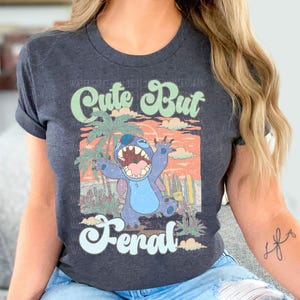 a woman sitting on a couch wearing a shirt with a cartoon character on it