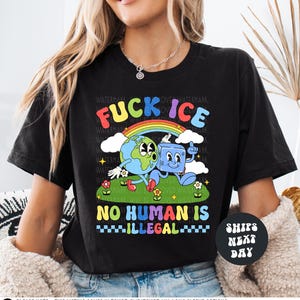 a woman wearing a black t - shirt with a cartoon character on it