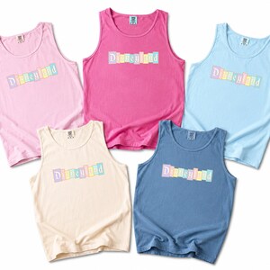 a collection of five colorful tank tops, each with the word "Disneyland" printed on them.