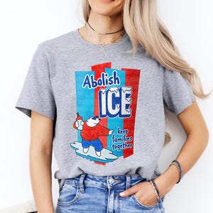 a woman wearing a grey t - shirt with a cartoon character on it