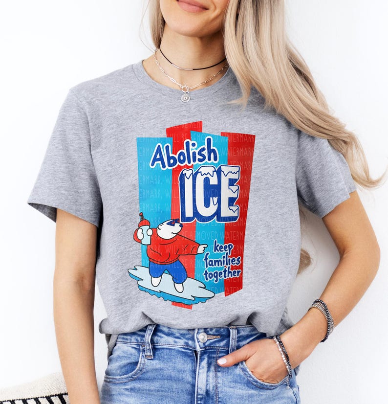 a woman wearing a grey t - shirt with a cartoon character on it