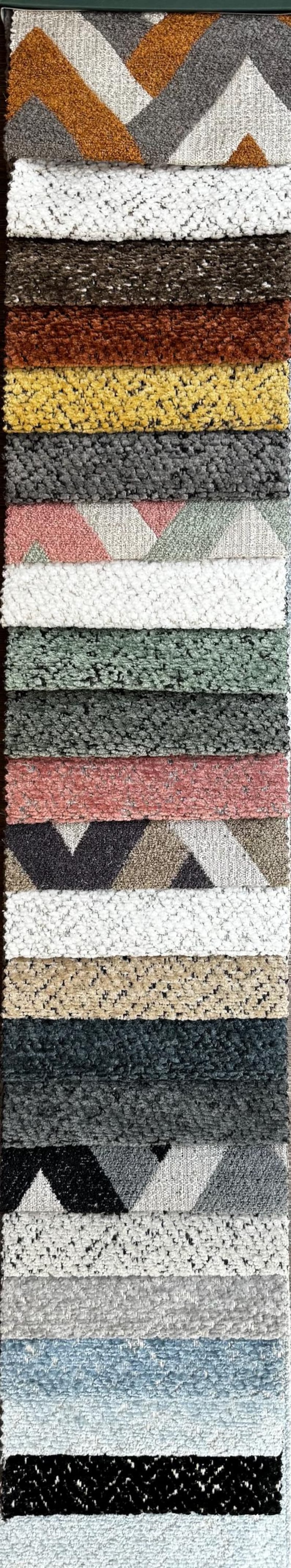 May include: A vertical display of various textured fabric swatches. The samples showcase a range of colors, including gray, white, brown, and blue. Some swatches feature geometric patterns, while others have a solid, plush appearance. Ideal for home decor.