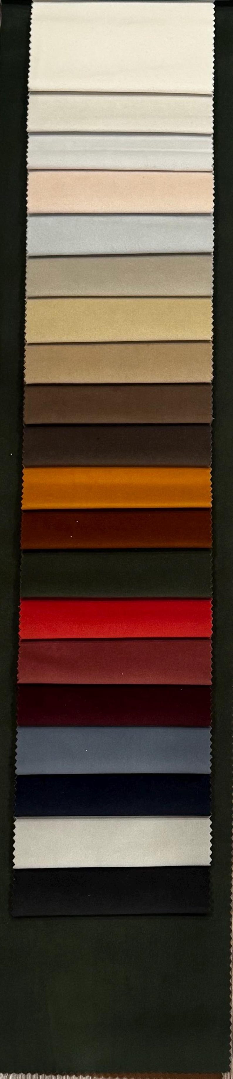 May include: A vertical swatch card featuring a variety of fabric samples in shades of beige, brown, red, and blue. The samples are arranged in horizontal rows, showcasing different textures and colors for upholstery or textile design.